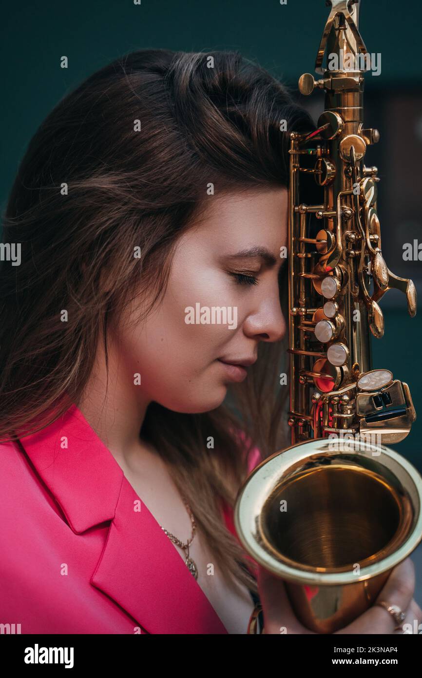 girl touches the head of the saxophone Stock Photo - Alamy