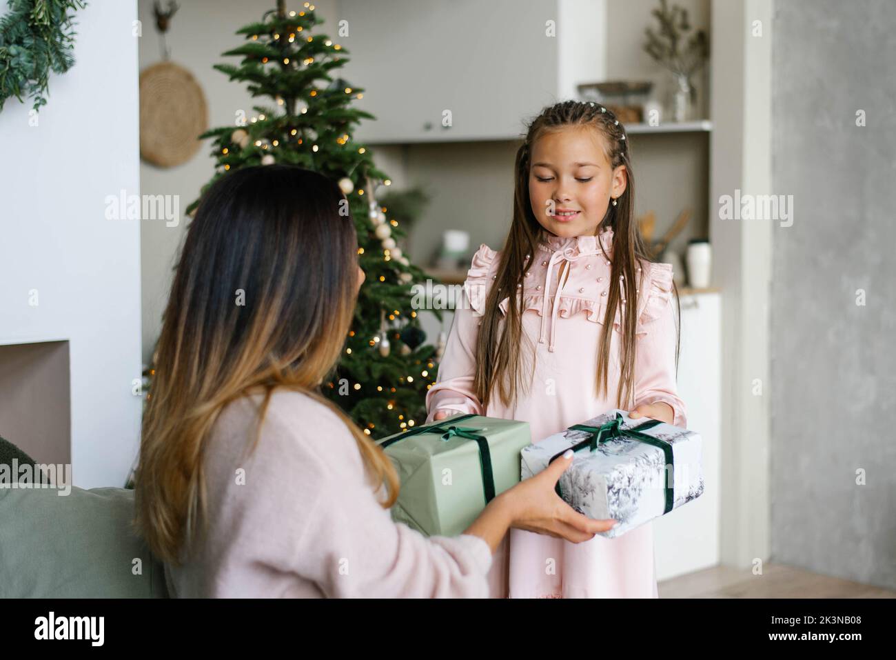 Mom and daughter give each other Christmas gifts Stock Photo