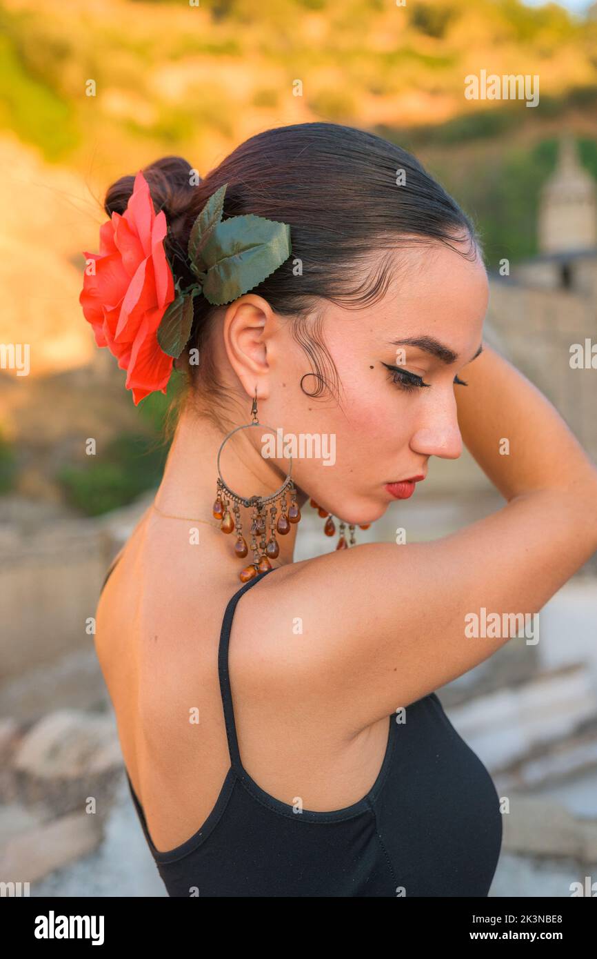 Woman puts a red flower in her hair Stock Photo