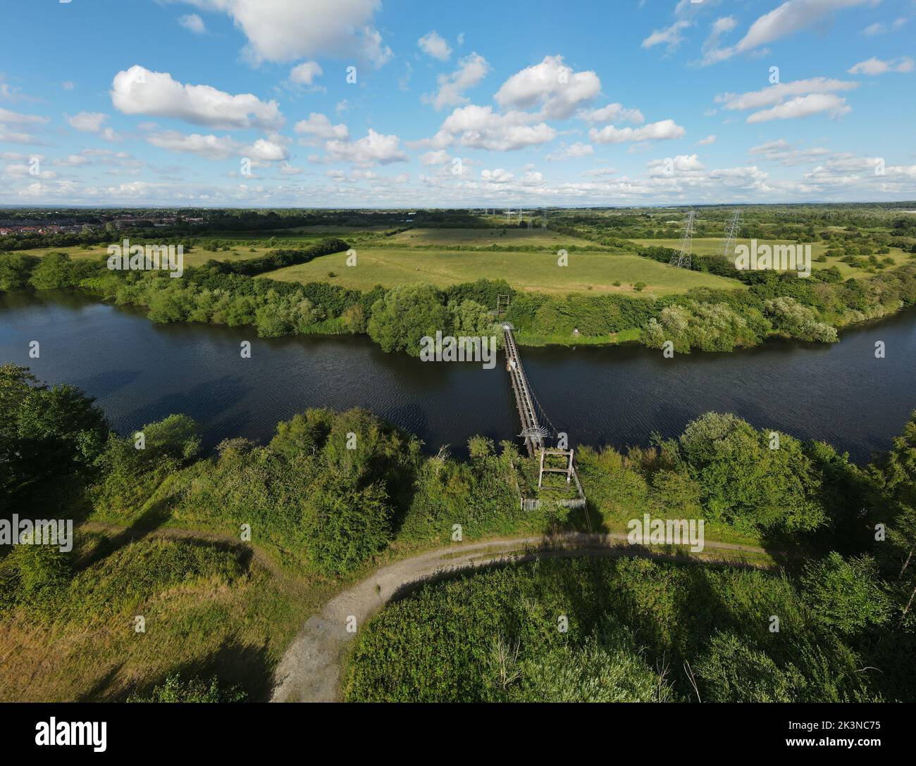 An aerial view of a landscape with a bridge over a river and meadows ...