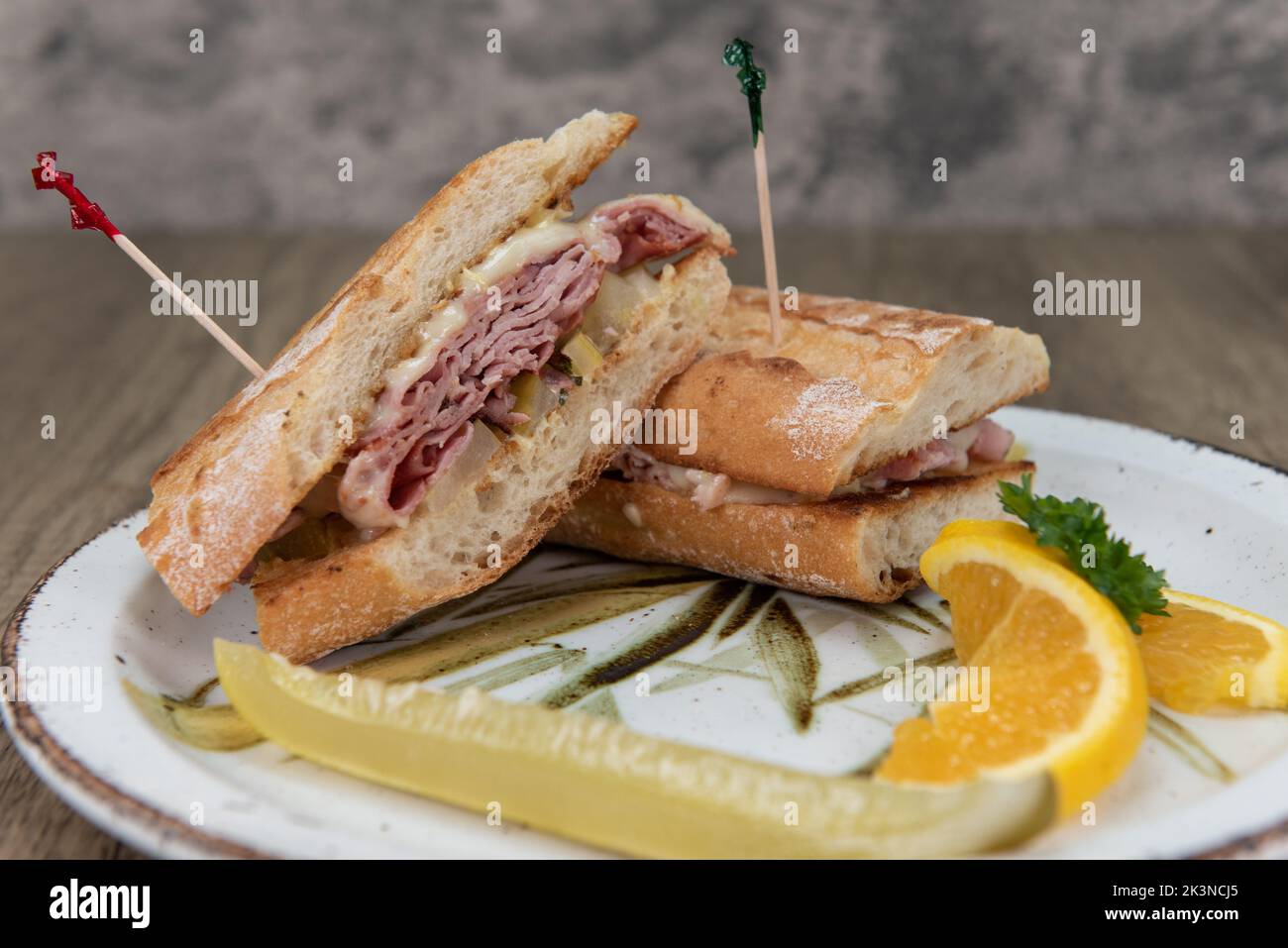 Cubano sandwich with melted swiss cheese over ham in a freshly baked baguette bread bun. Stock Photo