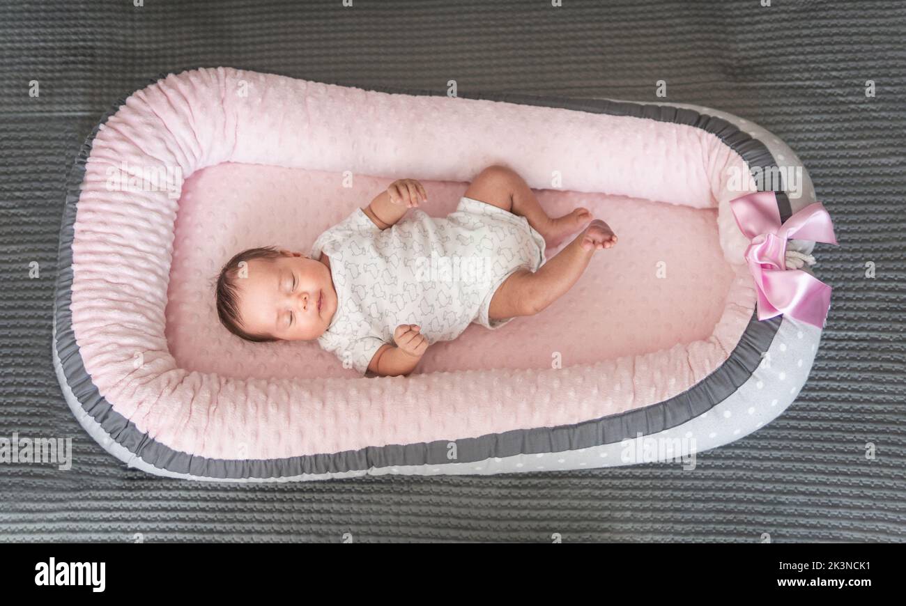 Topview of a sleeping baby girl in a pink crib at home Stock Photo
