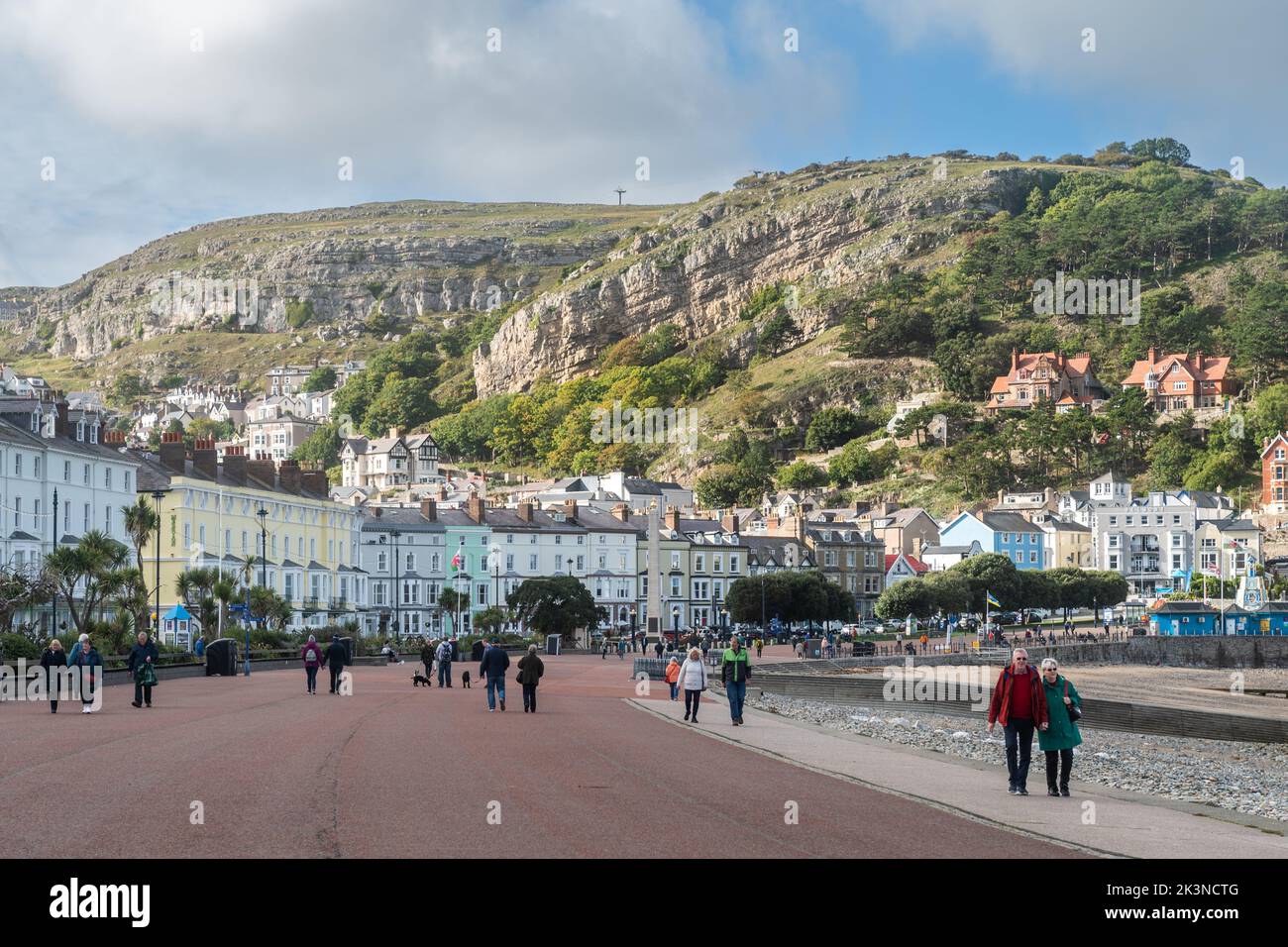 People walking along the promenade with the Great Orme in the