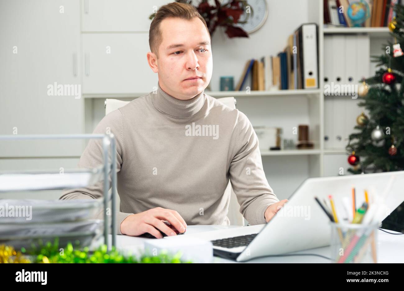 Man working in Christmas decorated office Stock Photo