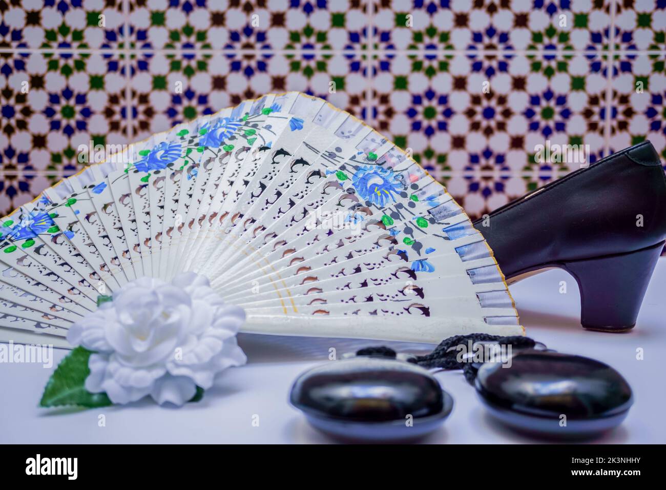 typical spanish flamenco accessories castanets,fan,and high heels on a white table Stock Photo