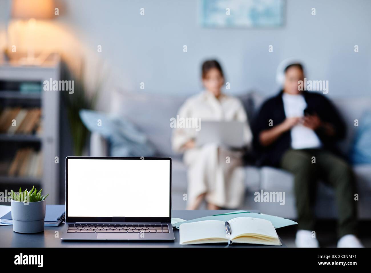 Background image of laptop with black white screen mockup in home interior with two women, copy space Stock Photo