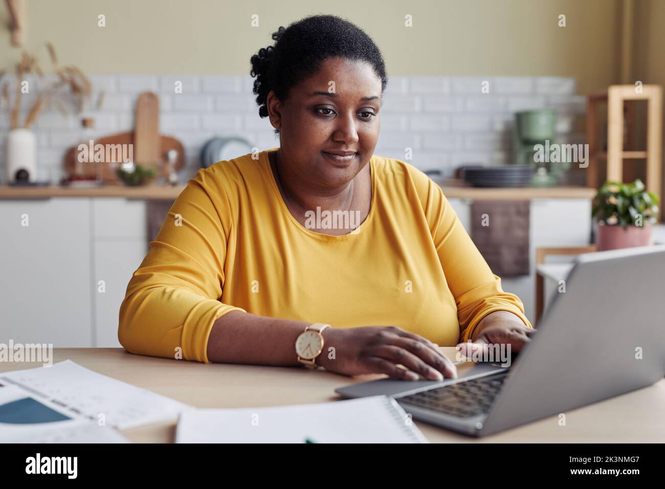 Smiling black young woman doing business while working from home Stock Photo