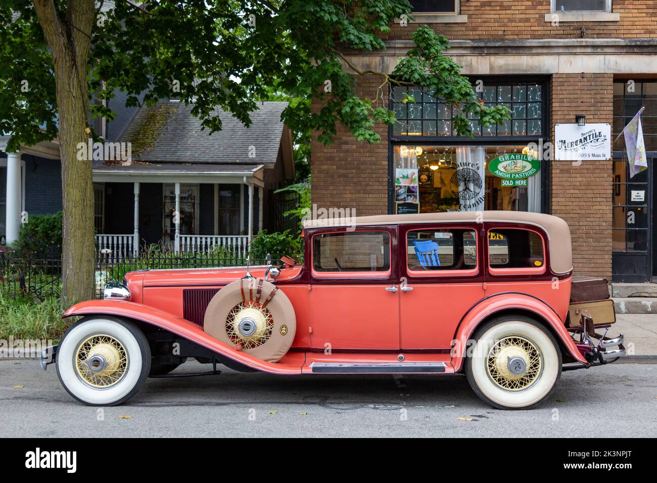 An antique orange Cord L-29 sedan with suicide doors is parked along Main Street in Auburn, Indiana, USA. Stock Photo