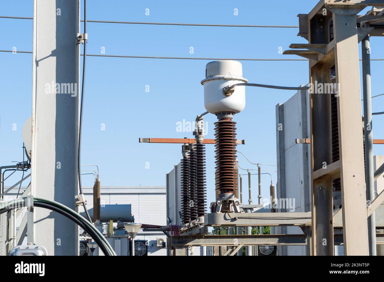 An industrial substation of high voltage electrical power under a blue ...