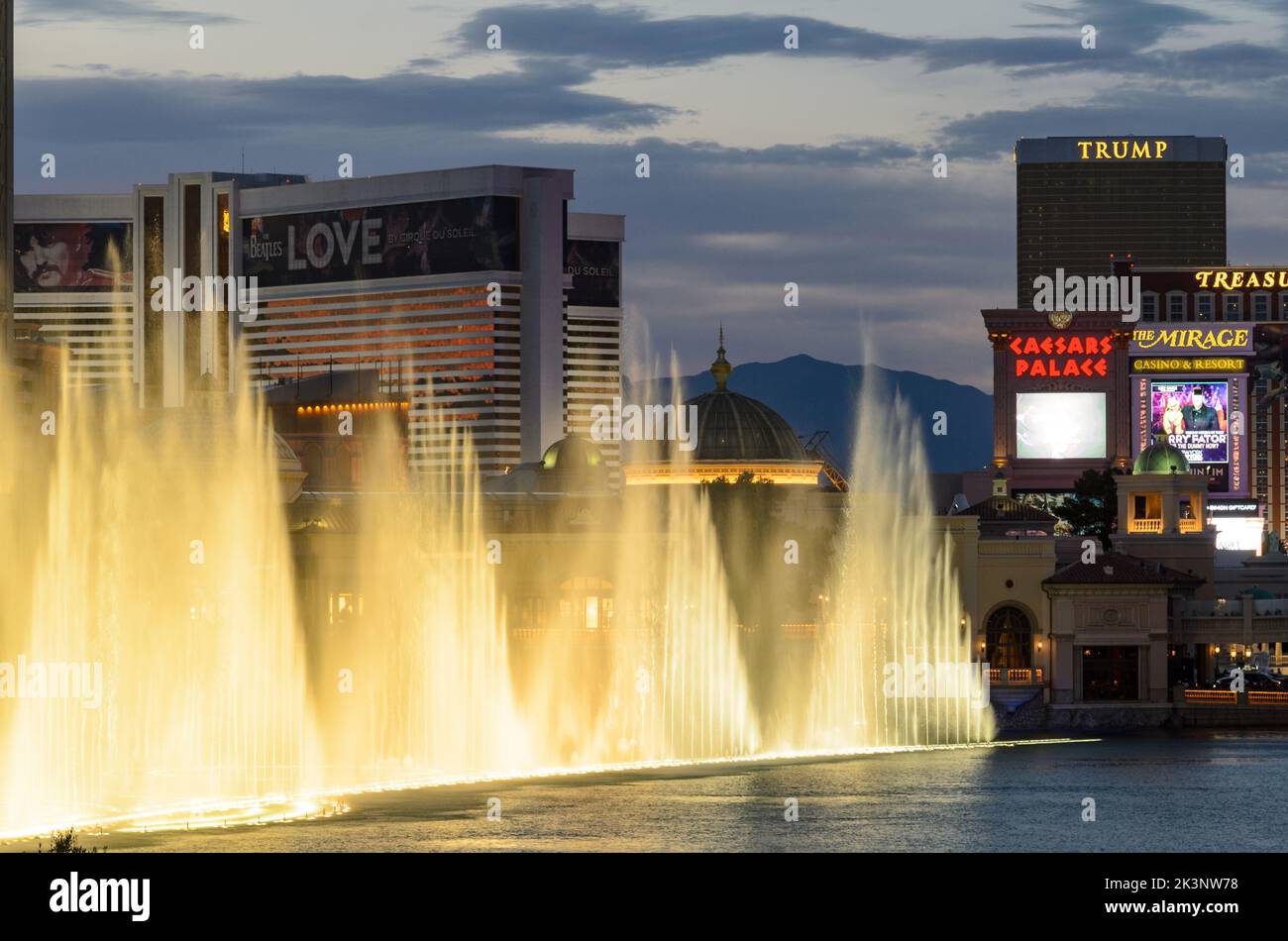 The Bellagio Fountains in front of the Bellagio Casino, with Ceasers Palace and the Las Vegas Strip visible in the background in Las Vegas, Nevada, US Stock Photo