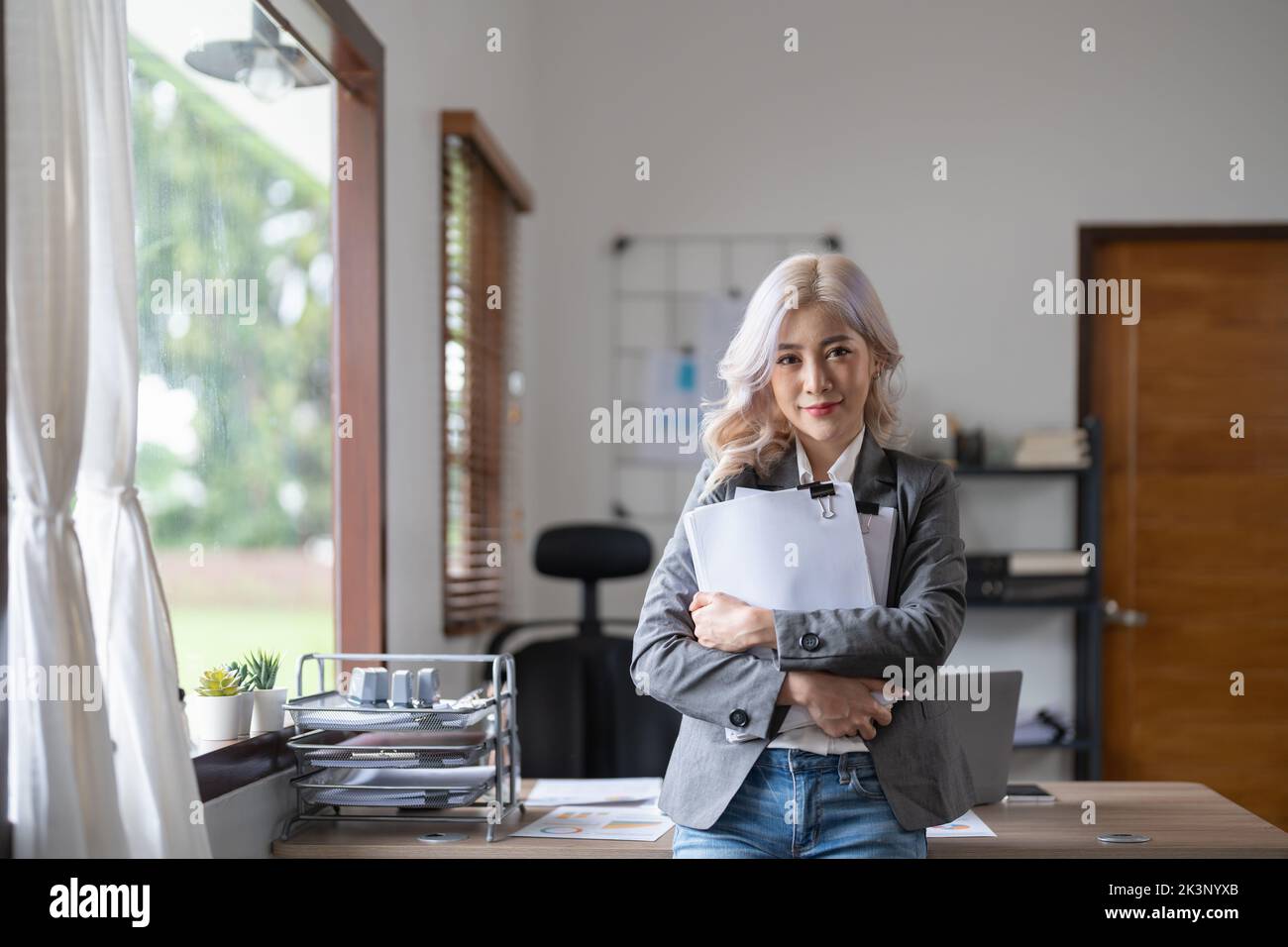 Portrait attractive business asian woman standing in front of work desk. Stock Photo