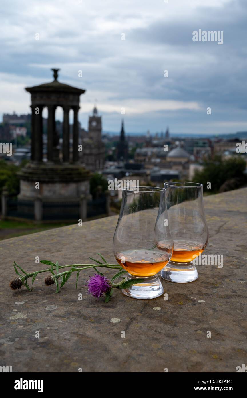Two glasses of single malt scotch whisky and view from Calton hill to park and old parts of