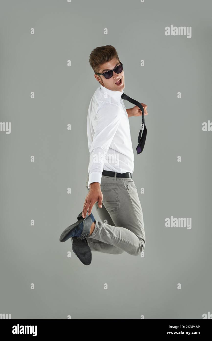 Charisma and energy. Portrait of a young man looking back while jumping in the air. Stock Photo