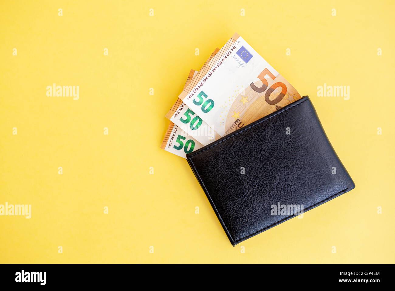 Fifty euro banknotes inside a black wallet on yellow background, cash paper currency, payment, earning and savings, european currency, money and finan Stock Photo