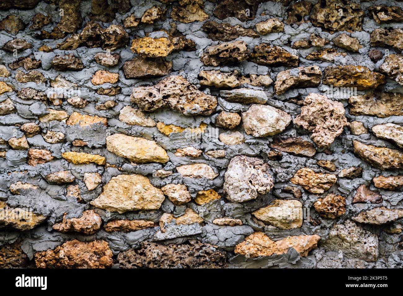 Old style wall made of rough stones with cement. Ancient grunge stones ...