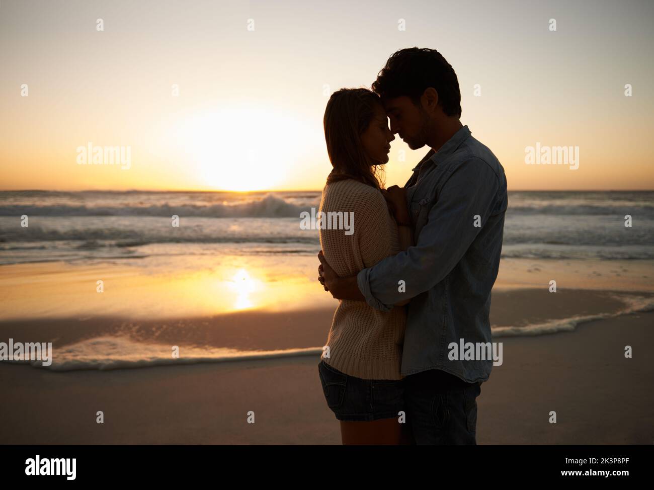 Relishing this moment. A blissful young couple celebrating their love at sunset on the be. Stock Photo
