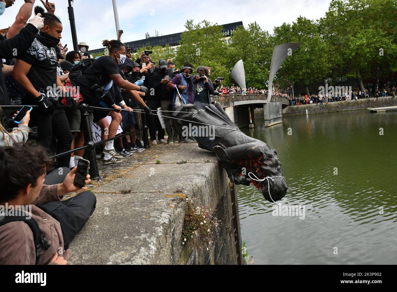 File photo dated 7/6/2020 of protesters throwing the statue of Edward Colston into Bristol harbour during a Black Lives Matter protest rally, as a ruling on legal issues arising out of the acquittal of four people who were prosecuted for pulling down a statue of slave trader Edward Colston during a Black Lives Matter protest - the so-called Colston Four - will be delivered by judges. Stock Photo