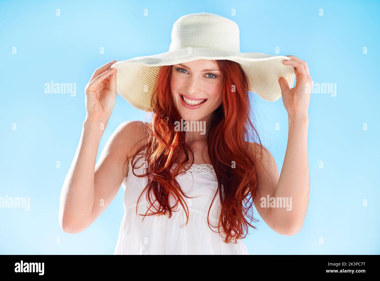Protecting her delicate skin. A gorgeous young redheaded woman wearing a sunhat outside. Stock Photo