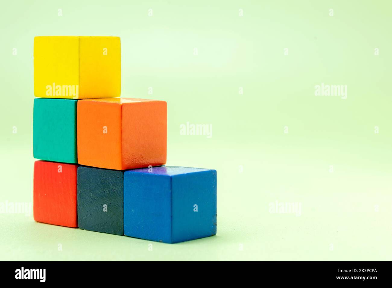Stairs of colorful wooden block toys on a colored background Stock Photo