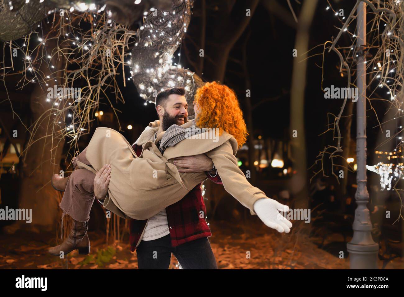 A man carries his wife on a beautiful winter night Stock Photo