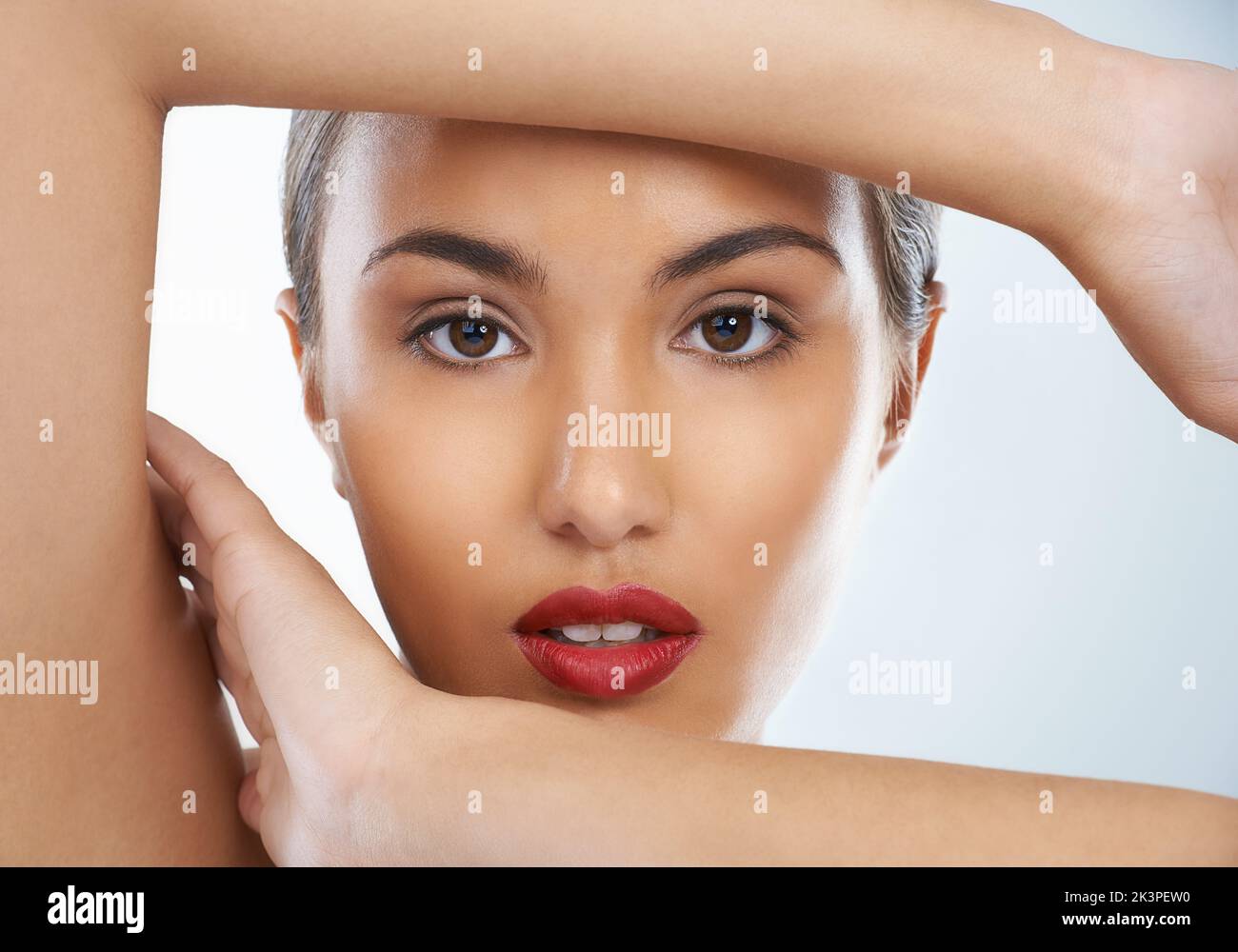 Framing her natural beauty. Closeup beauty shot of an attractive young woman framing her head with her arms. Stock Photo