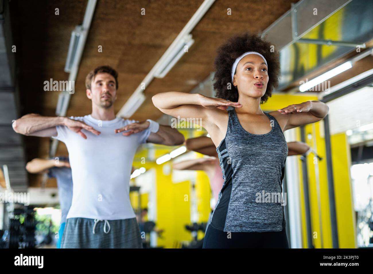 Fitness, sport, people and lifestyle concept. Group of smiling people exercising together in gym Stock Photo