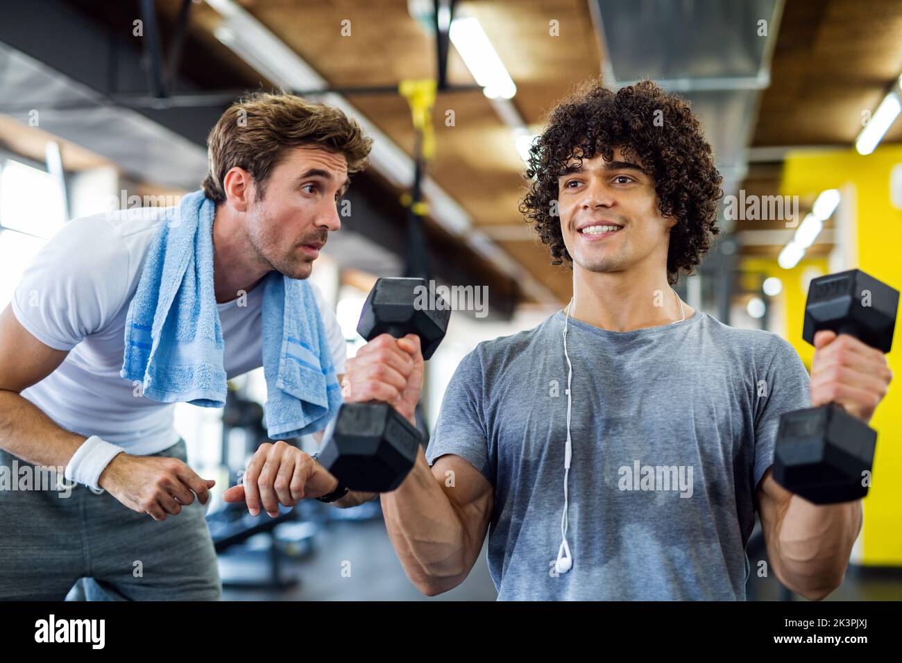 Fitness, sport, exercising concept. Fit man exercising together with his personal trainer in gym. Stock Photo