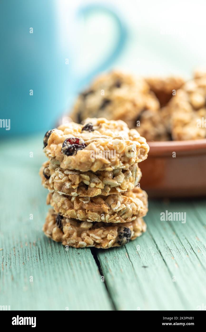 Wholegrain oat cookies. Cookies with oatmeal and raisins on the green wooden table. Stock Photo