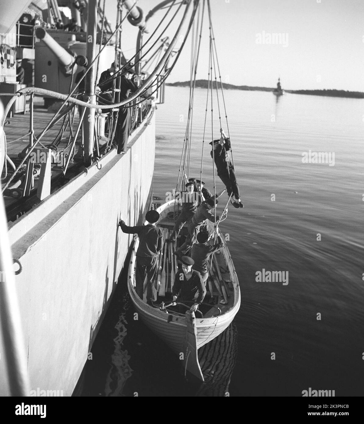 During World war II. The war ship Sverige during navy exercises at sea. The life boat is being fitted and has been lowered down in the water. Sweden june 1940. Kristoffersson ref 141 Stock Photo