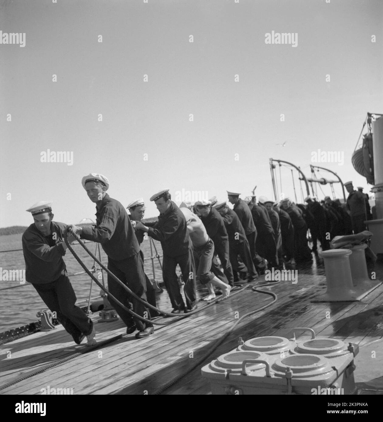 During World war II. The war ship Sverige during navy exercises at sea. The sailors are all pulling something heavy on deck, like an anchor line. Sweden june 1940. Kristoffersson ref 141 Stock Photo