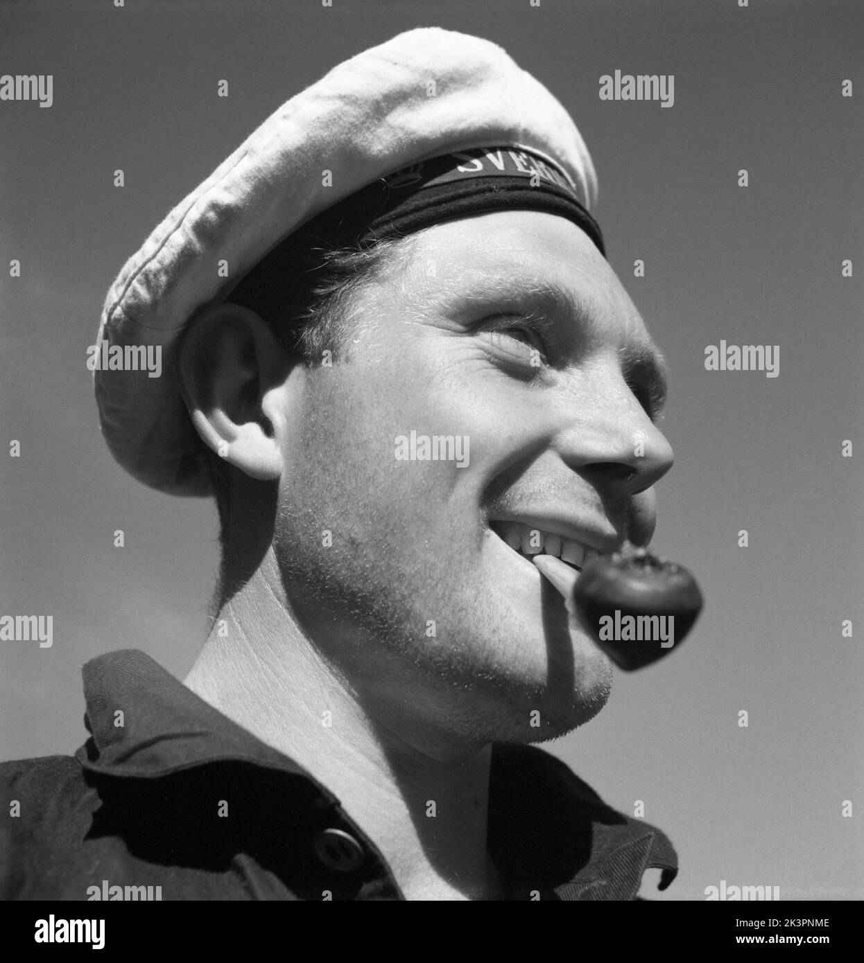 During World war II. The war ship Sverige during navy exercises at sea. Detail of a sailor in uniform and hat smoking his pipe. Sweden june 1940. Kristoffersson ref 141 Stock Photo