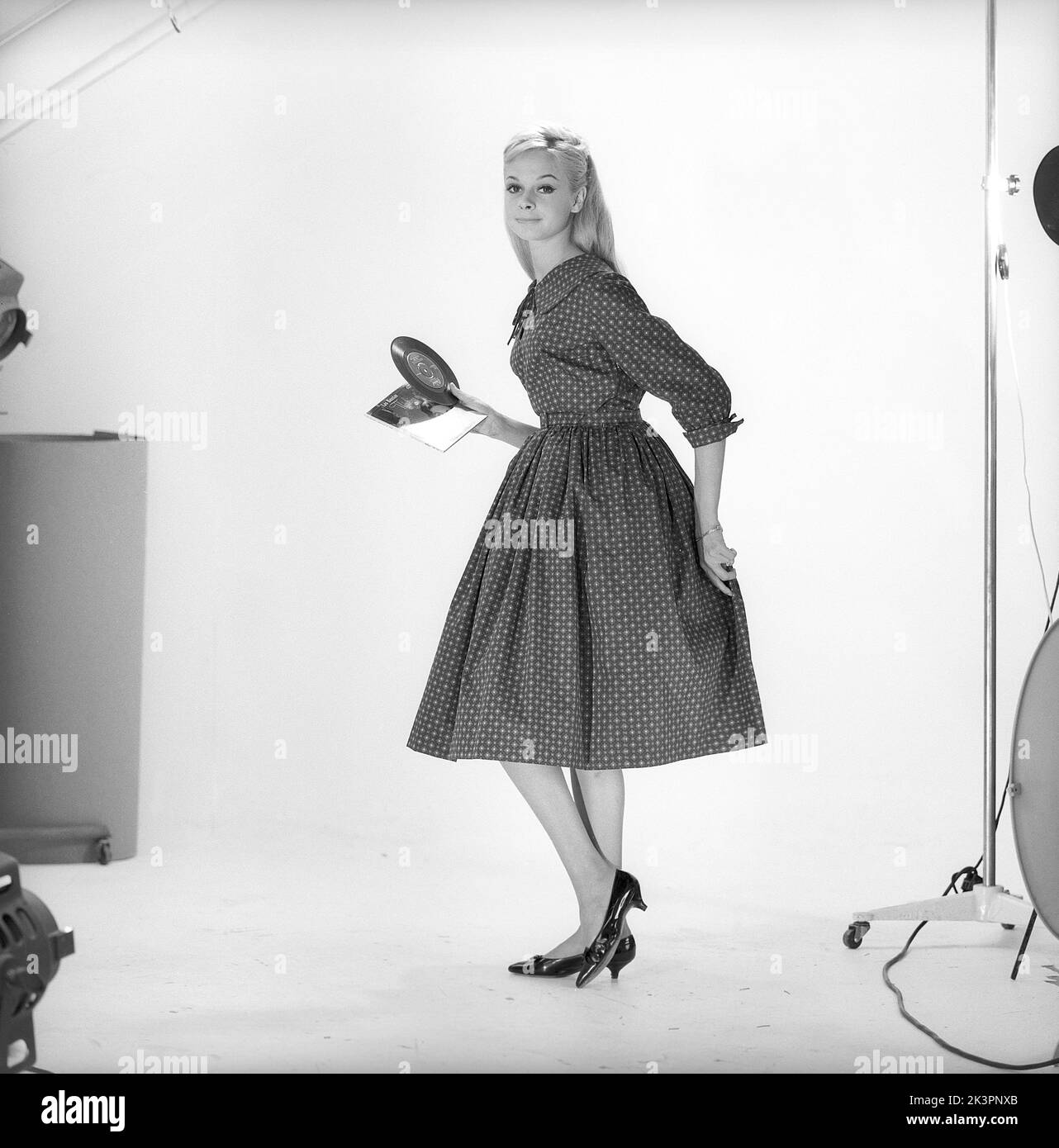 1950s fashion. A young woman in a typical 1950s dress. A wide skirt dress with a 50s patterened fabric.  Sweden 1959. Kristoffersson ref CO93-10 Stock Photo