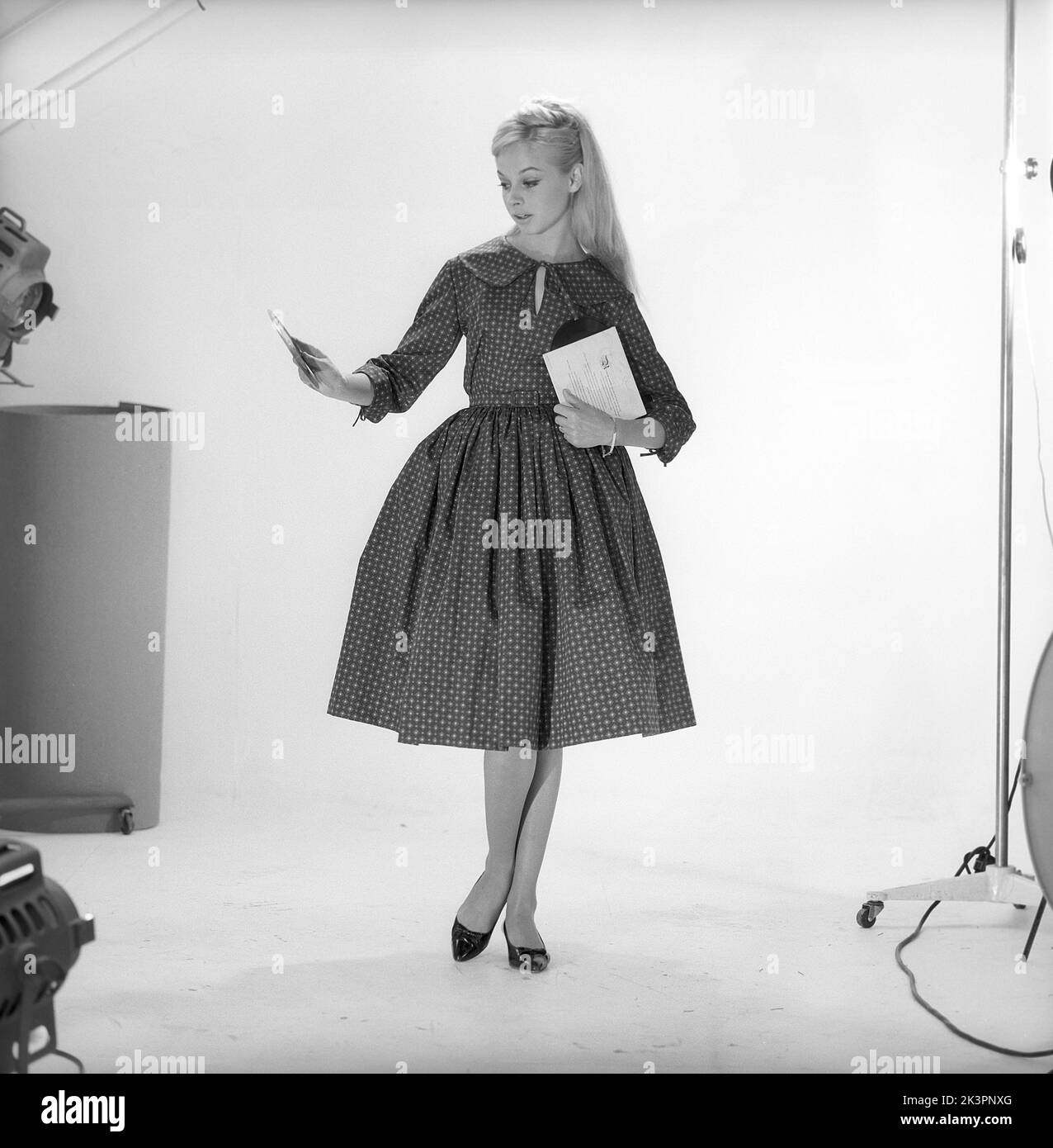 1950s fashion. A young woman in a typical 1950s dress. A wide skirt dress with a 50s patterened fabric.  Sweden 1959. Kristoffersson ref CO93-2 Stock Photo