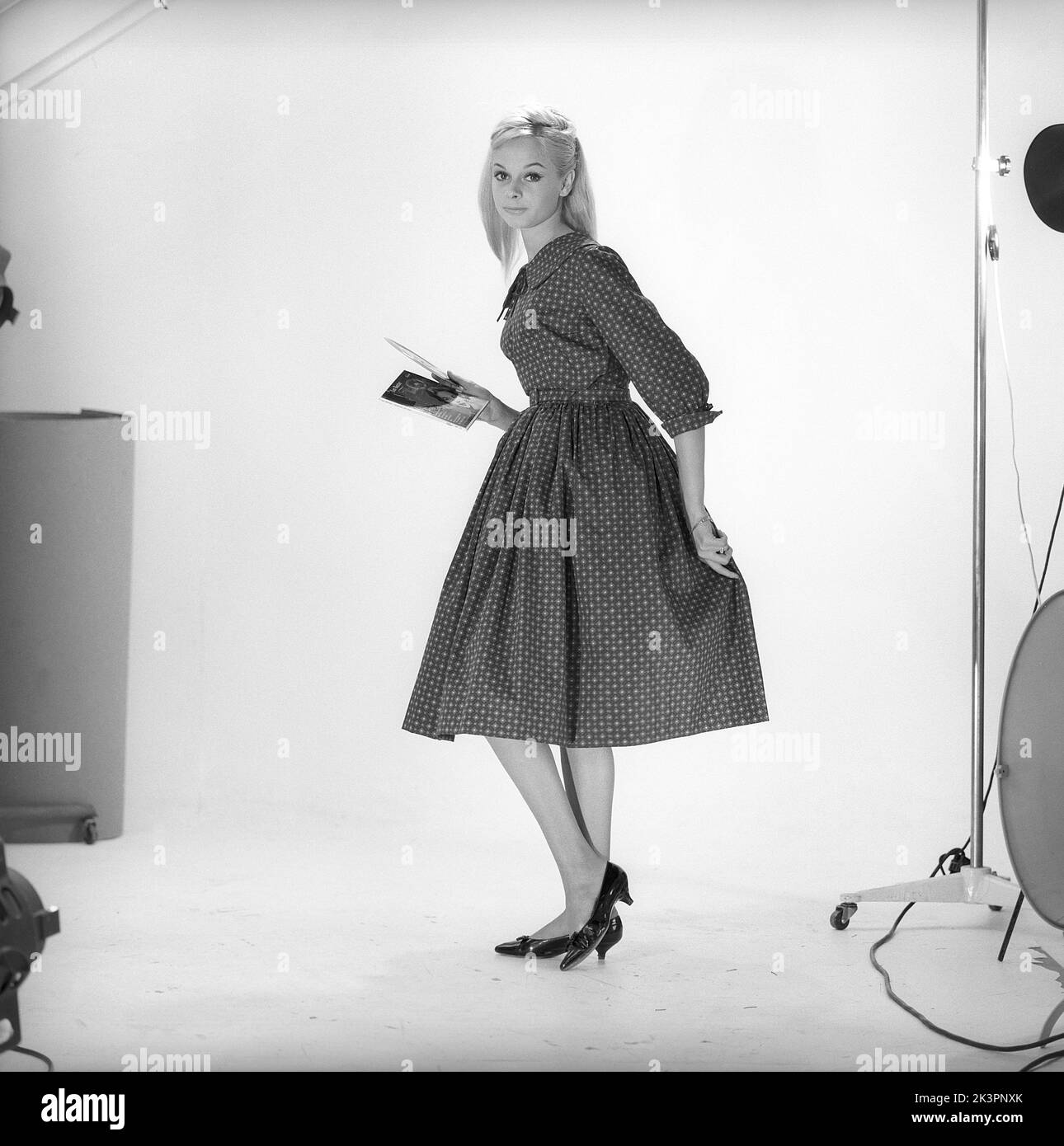 1950s fashion. A young woman in a typical 1950s dress. A wide skirt dress with a 50s patterened fabric.  Sweden 1959. Kristoffersson ref CO93-8 Stock Photo