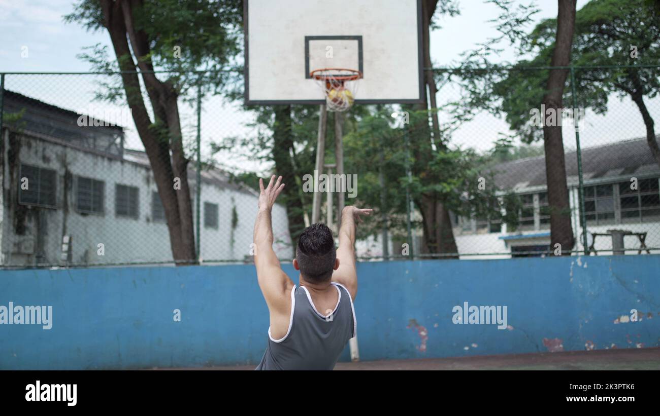 Disabled athlete scoring point throwing ball inside basketball net