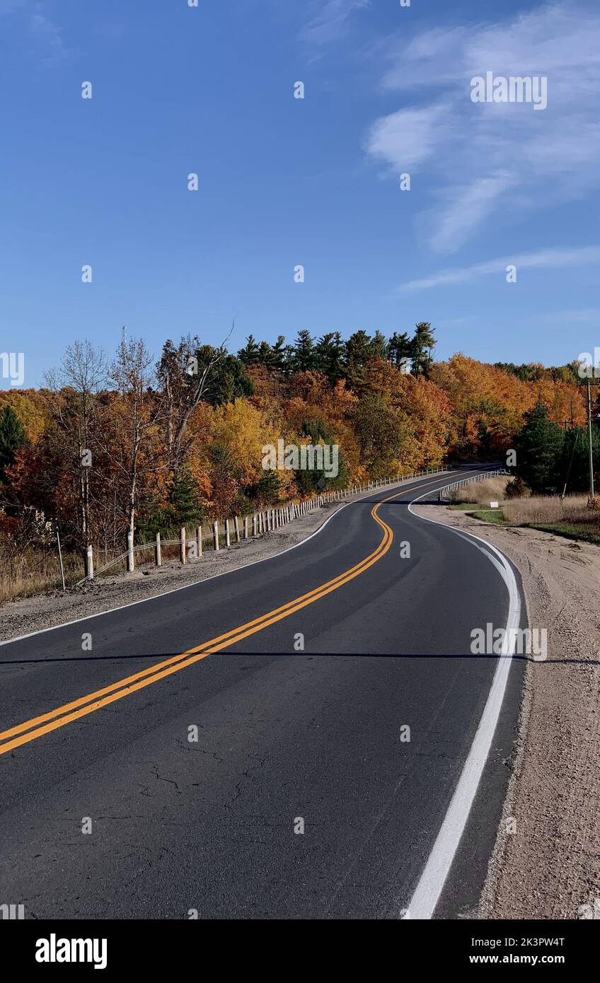 An aerial view of road surrounded by dense autumn trees Stock Photo - Alamy