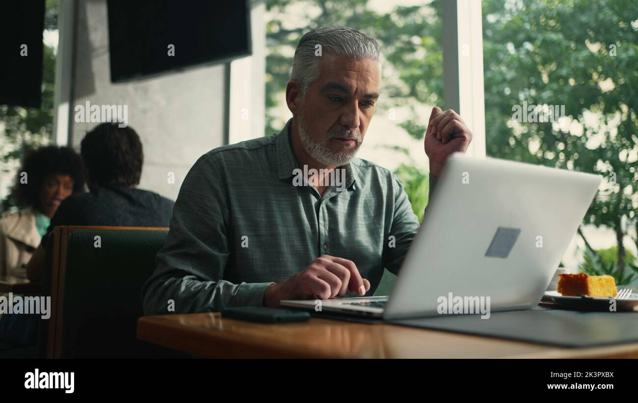 Older executive opening laptop seated hi-res stock photography and ...