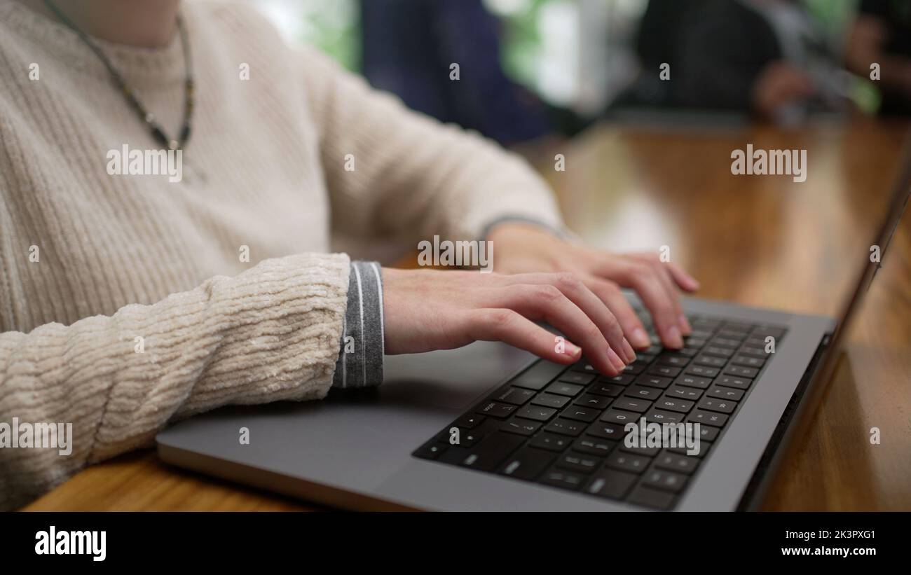 One young woman typing on laptop keyboard working remotely at coffee ...