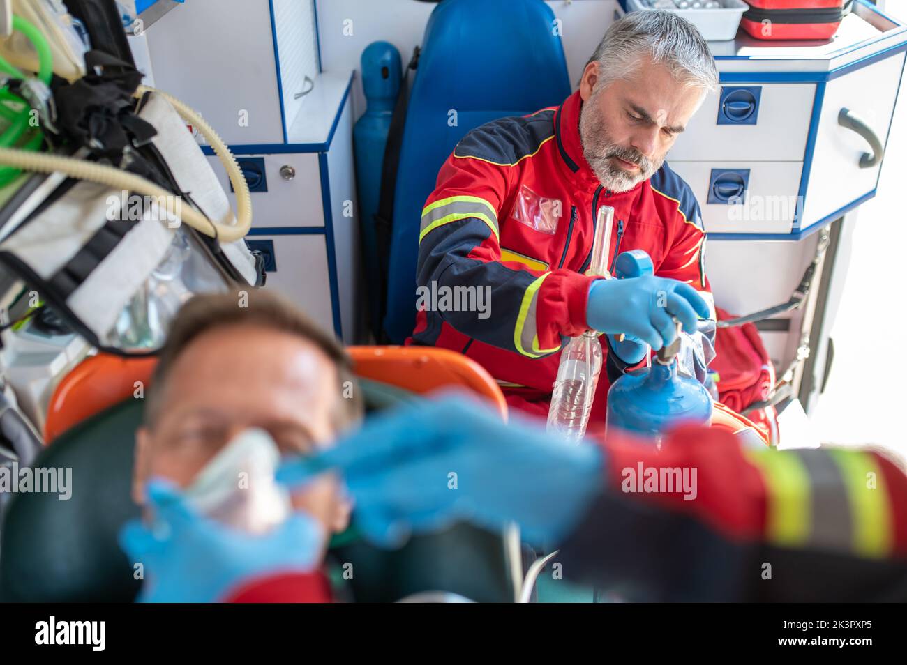 Paramedical staff oxygenating the patient in the ambulance car Stock Photo