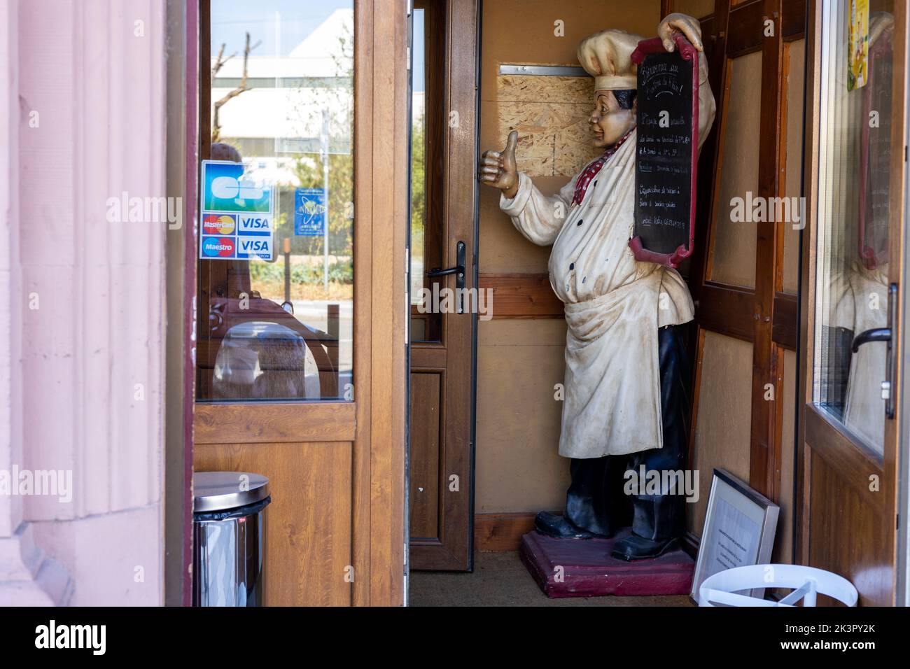 The entry to a restaurant with a mannequin chef holding the menu in Strasbourg, Alsace, France Stock Photo