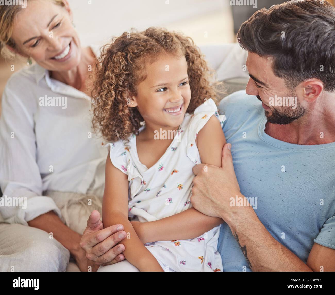 Happy family on sofa, smile together in living room and funny dad joke in Madrid home apartment. Child laughing at comic white father, parents relax Stock Photo