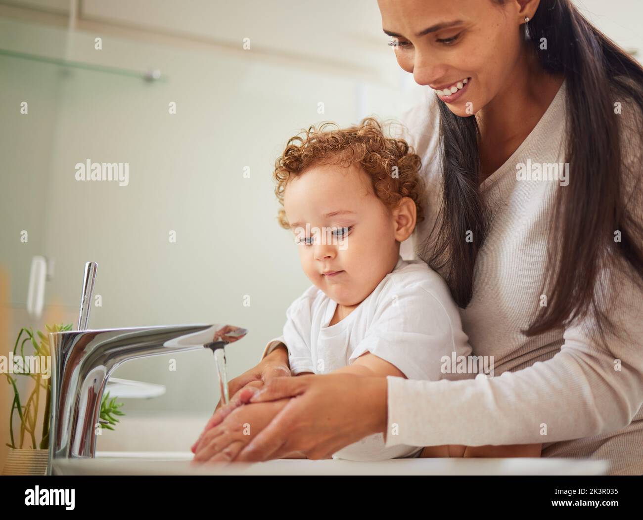 Mother, boy or washing hands help in water in covid bacteria cleaning, home morning wellness or learning hygiene. Child, son or kid by house bathroom Stock Photo