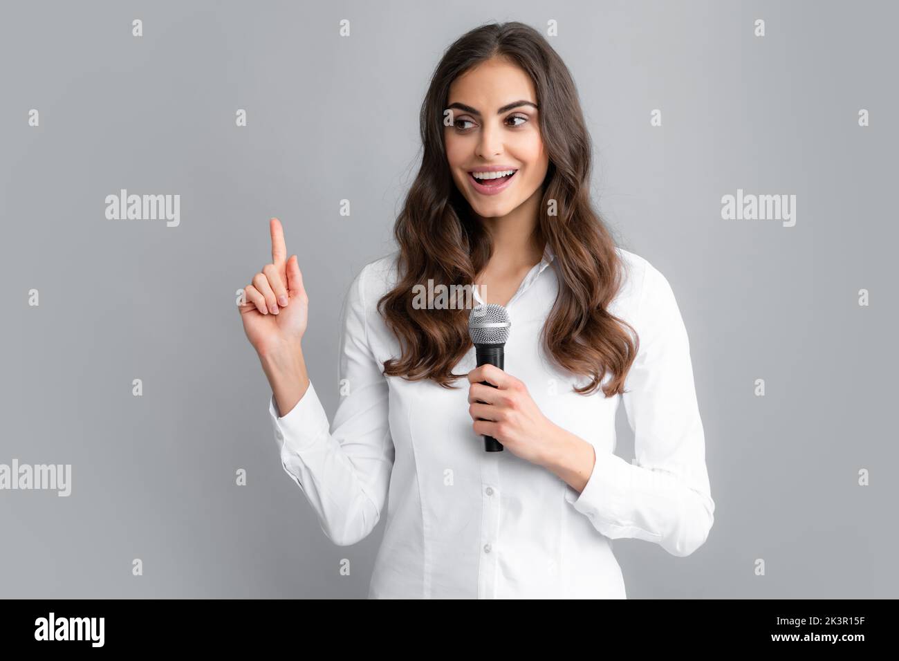 Woman speech, business woman holding a microphone. Young woman talking
