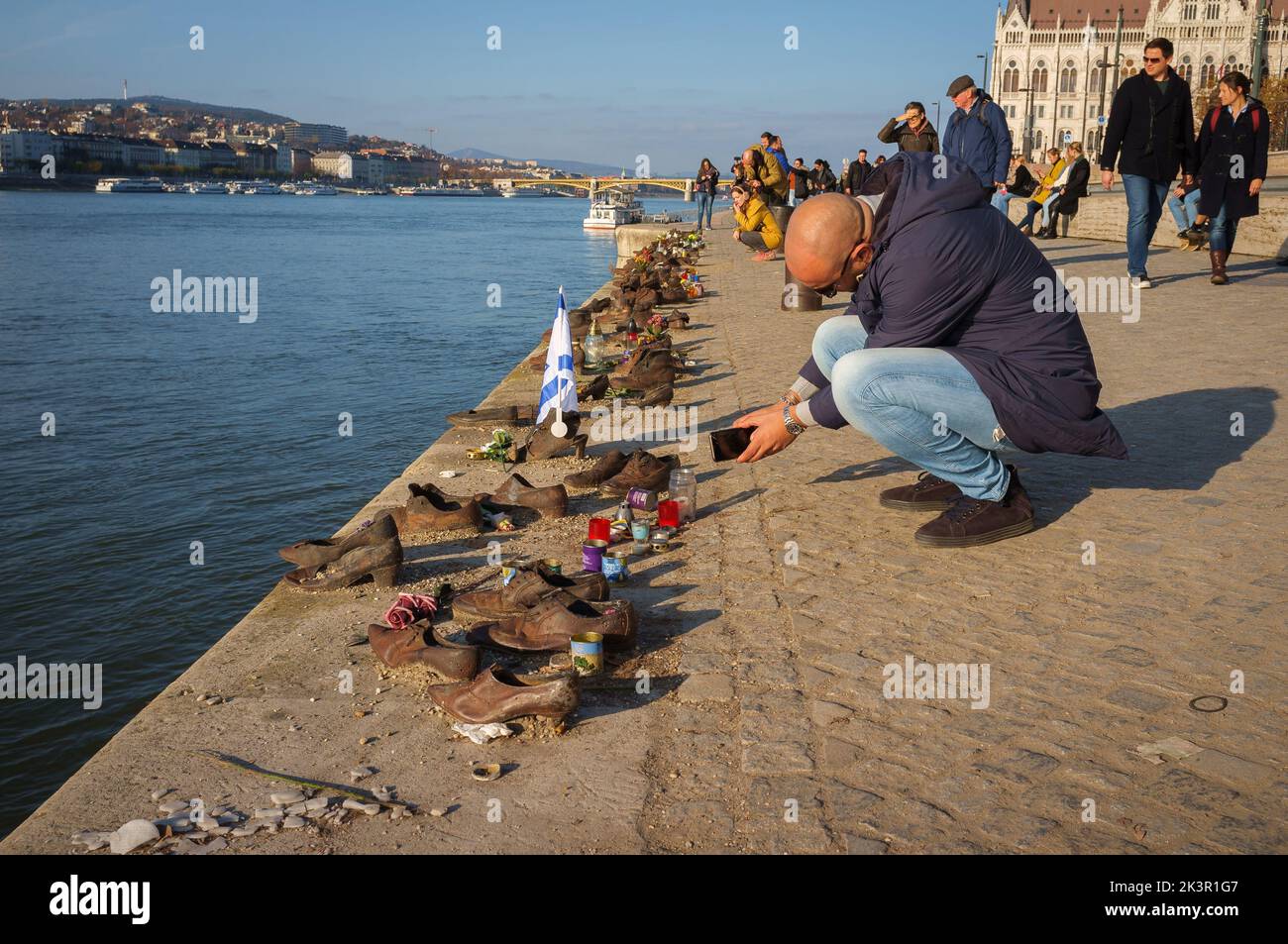 The tourists near Iron shoes memorial to Jewish people executed during WW2 in Budapest Stock Photo