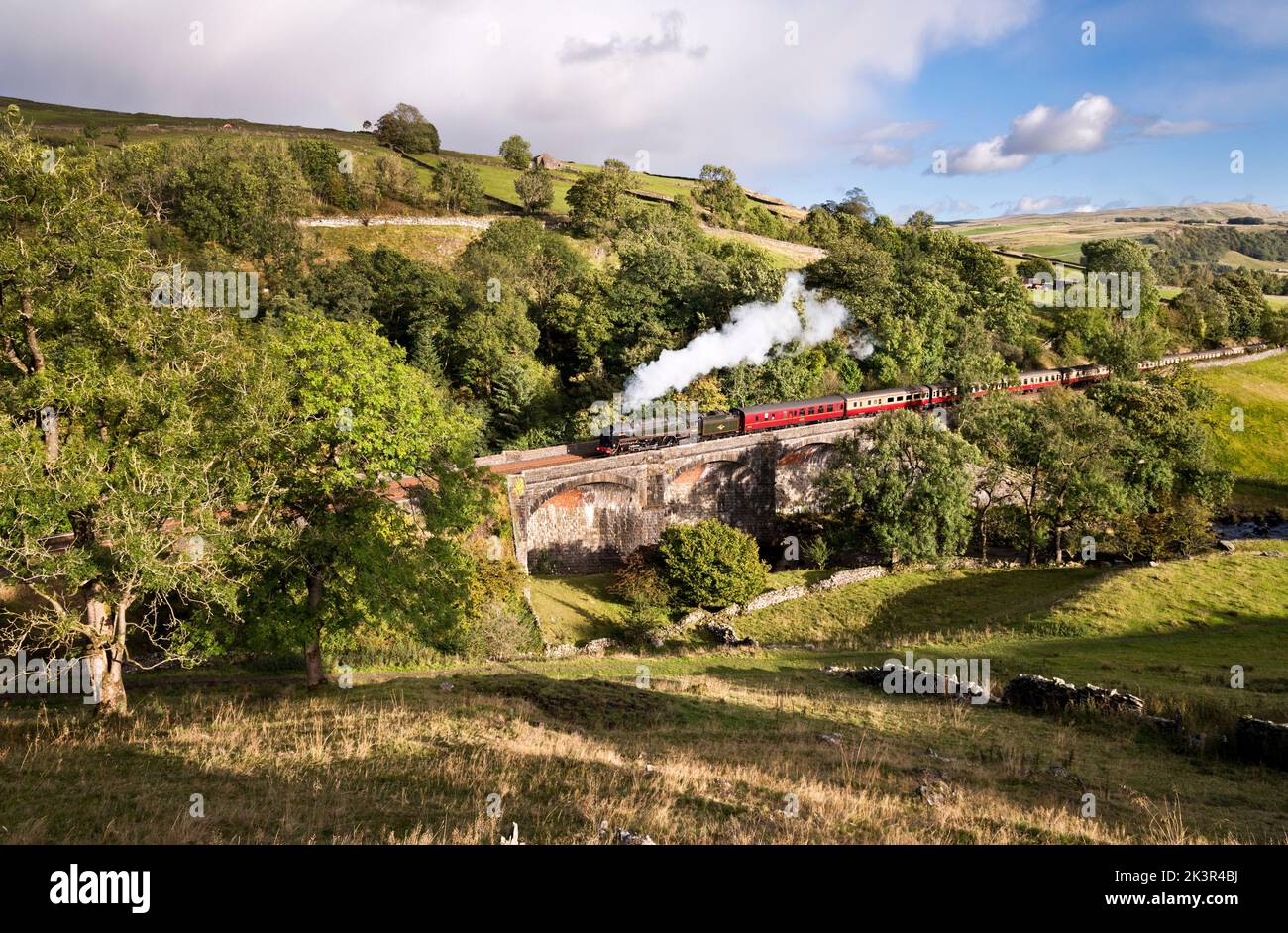 Locomotive 'Britannia' hauls a steam special northward up the steep gradient of the Settle-Carlisle line, Stainforth, Yorkshire Dales National Park Stock Photo