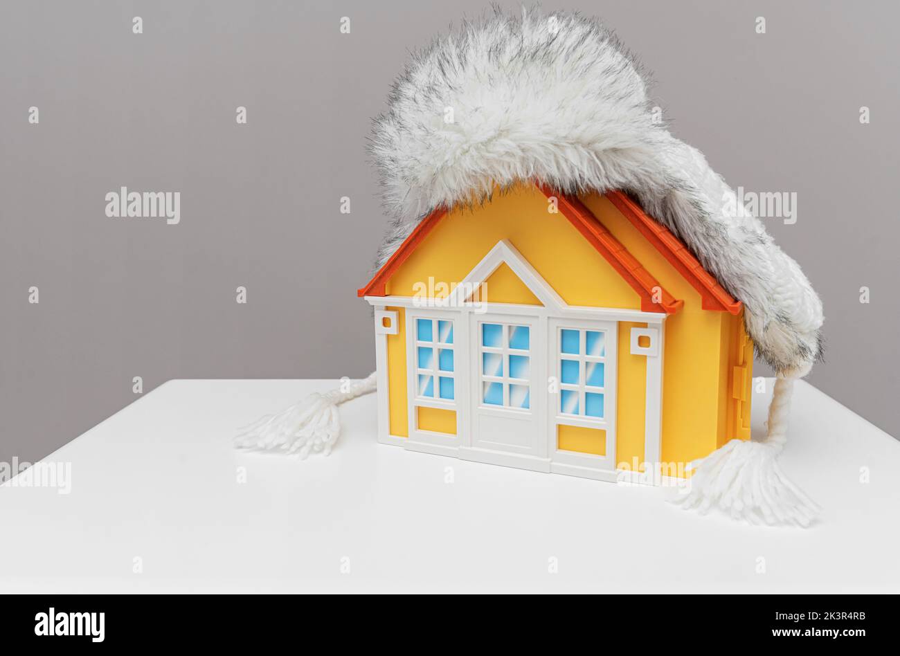 Warm hat with earflaps on the roof of the house. Stock Photo