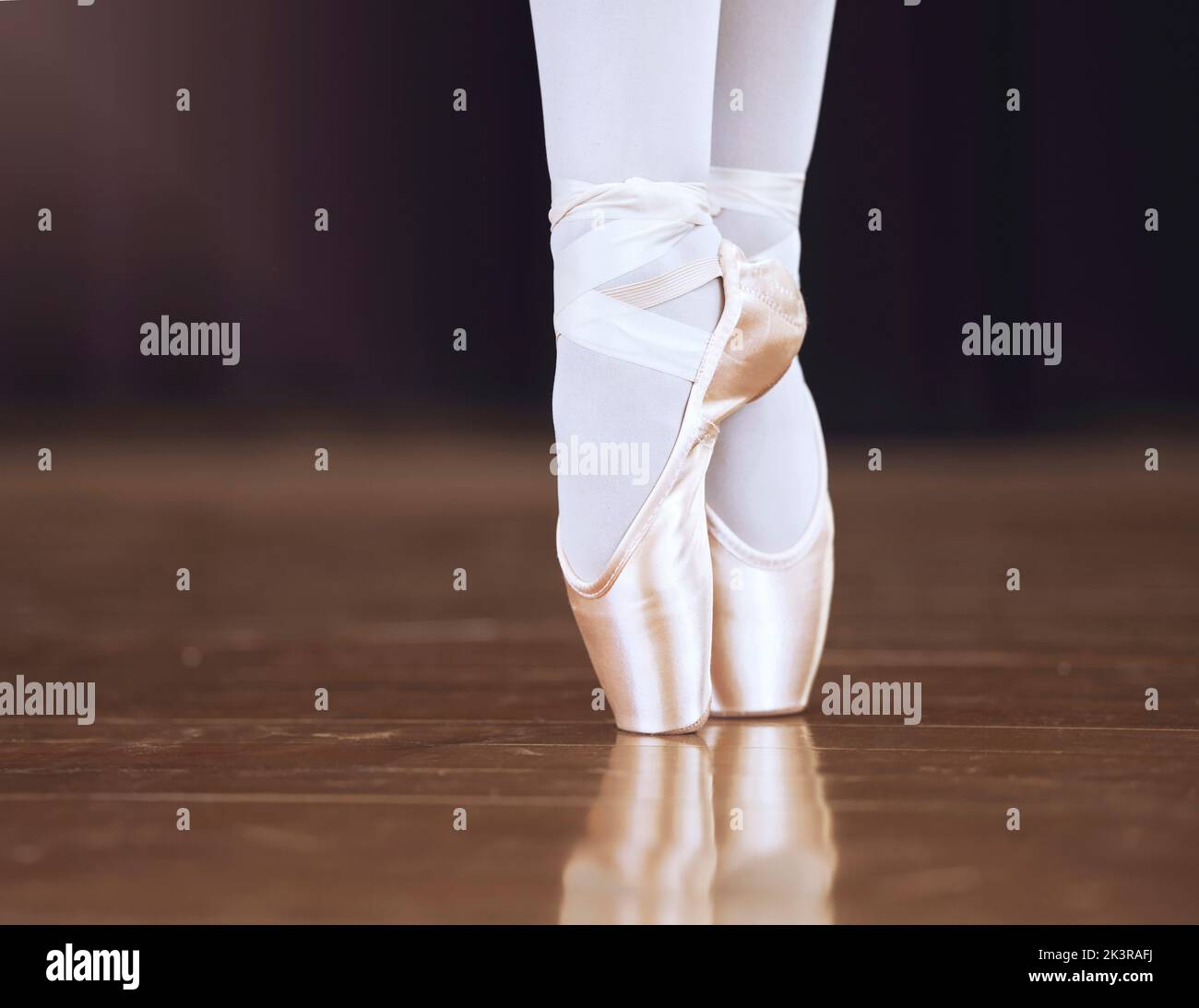 Ballet, dance and shoes with the feet of a ballerina or dancer dancing on a theater stage for a performance or show. Creative, art and training with Stock Photo