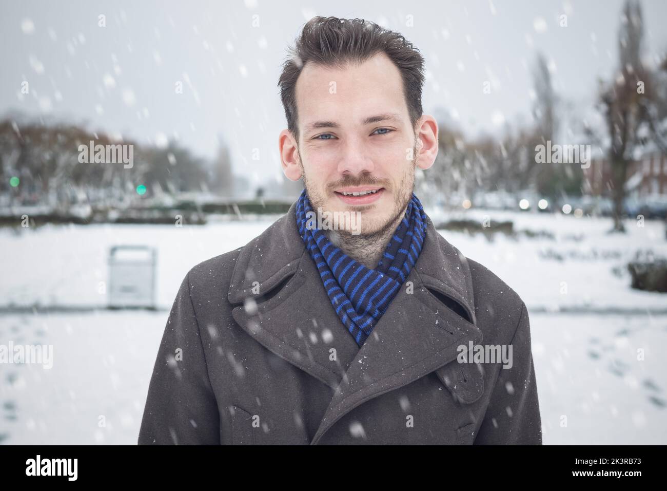 Portrait of a young handsome male with beard and moustache in winter snow Stock Photo