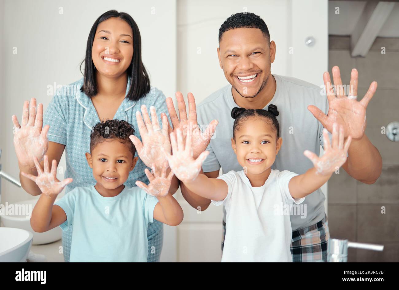 Parents, children and cleaning hands as a happy family in a bathroom together at home with a proud mother and father. Smile, dad and healthy mom Stock Photo