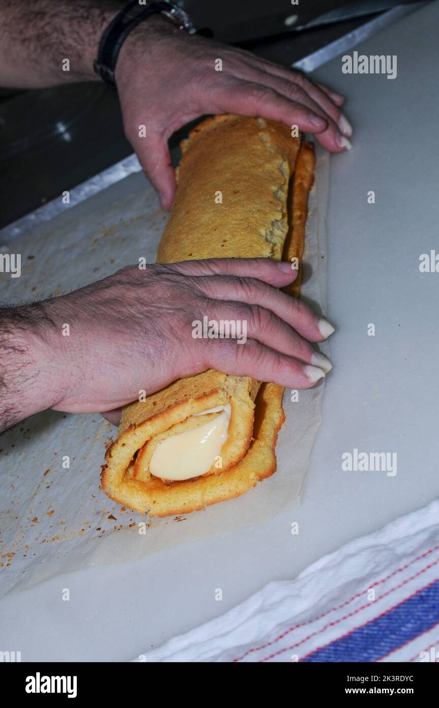 Chef preparing a swiss roll, covered in chocolate Stock Photo